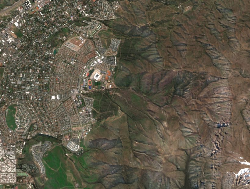 Vista amplia de San Carlos de Apoquindo y los cerros al oriente; el 11 de octubre la bruma y las nubes cubren la ladera quemada.