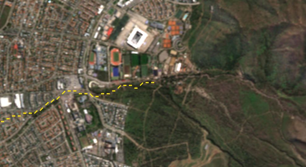 Acercamiento al borde urbano junto al estadio San Carlos de Apoquindo antes y después del aluvión; en la imagen del 11 de octubre un círculo naranjo marca una superficie parda nueva en un cruce de calles.