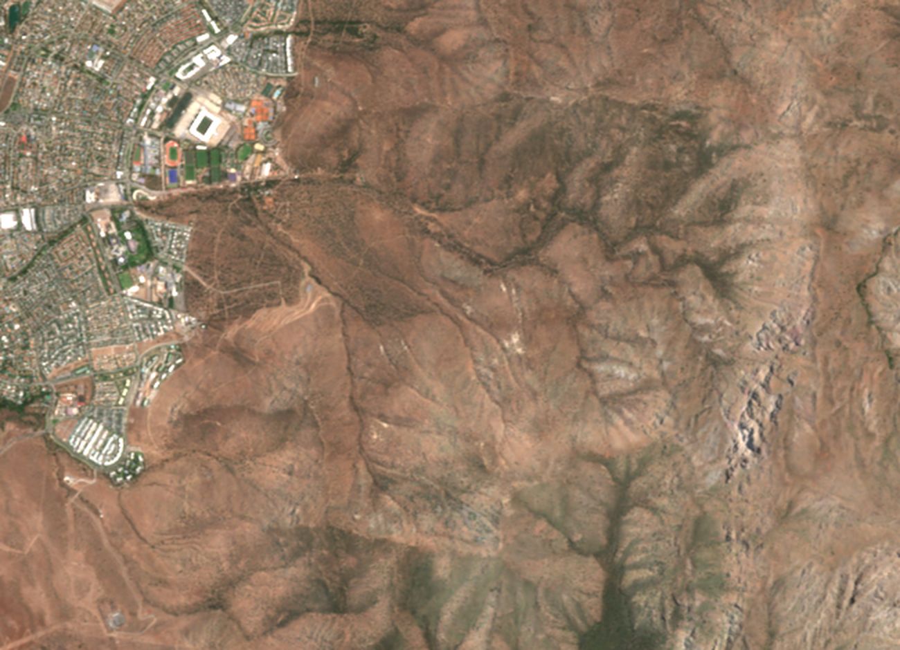 Cerros al oriente de San Carlos de Apoquindo antes y después del incendio de diciembre de 2025, en color natural.