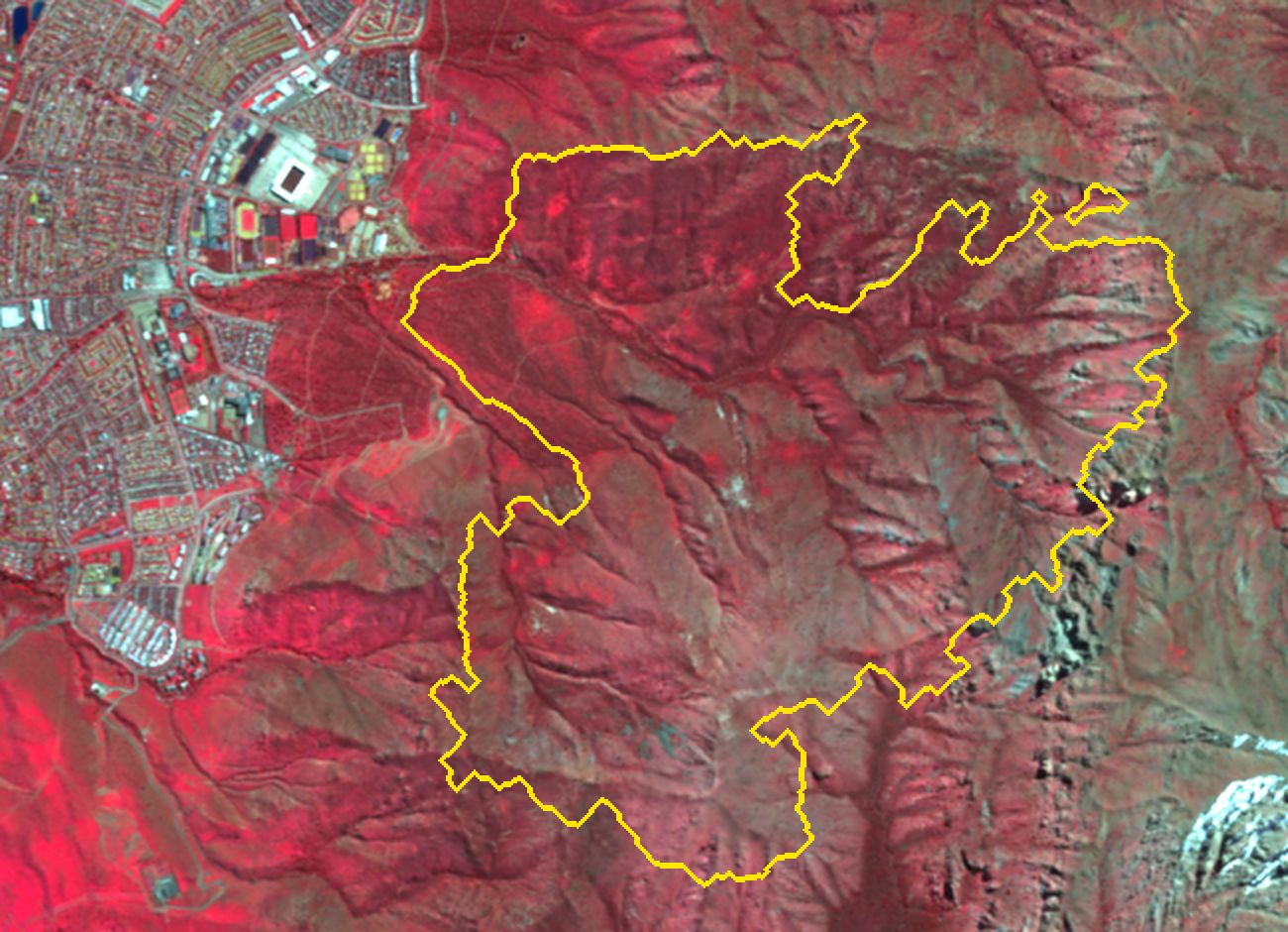 Los mismos cerros en falso color infrarrojo, septiembre de 2025 y septiembre de 2026. En 2026 la zona dentro del contorno amarillo se ve grisácea, mientras el entorno sigue rojo.